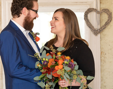 Wedding couple smiling with bouquet of flowers 