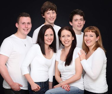 Professional portrait of adult siblings in family portrait studio with black background