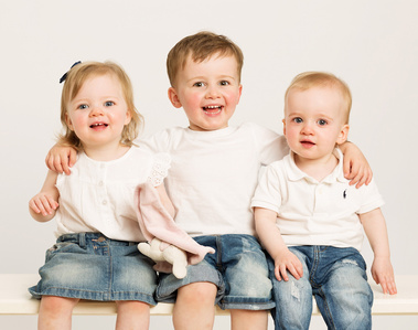 Children's Family portrait two brothers and sister white tops in professional photo studio white background