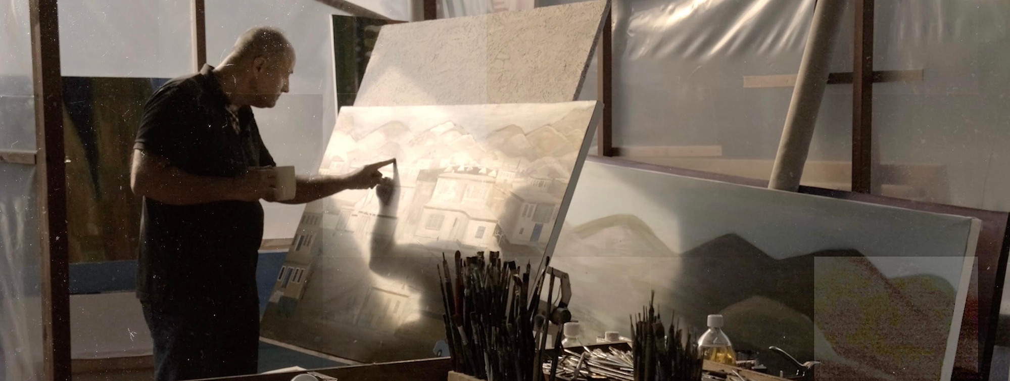 Bayram Gümüş examines the painting he continues to make in his workshop.