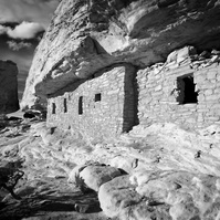 The Citadel Ruin perched high above Road Canyon on the cliffs edge with dramatic clouds hovering overhead.