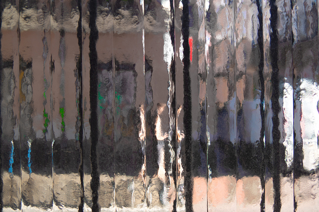 Street level photograph of a pedestrian on a Madrid street through a distorting window