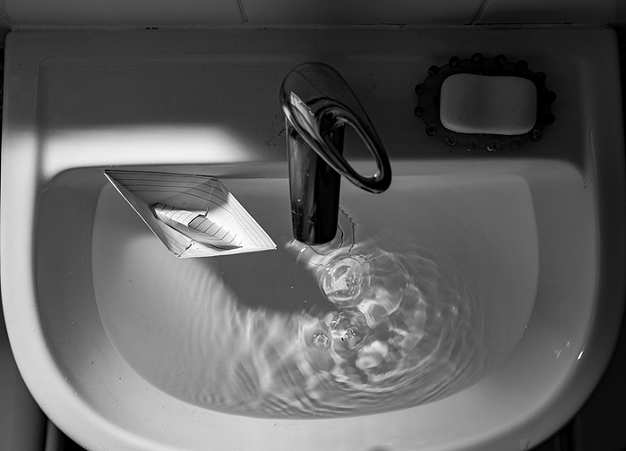 The paper ship is an analogy of our lives and tap water is an analogy of the passage of time.Sometimes it seems like our lives are going nowhere.