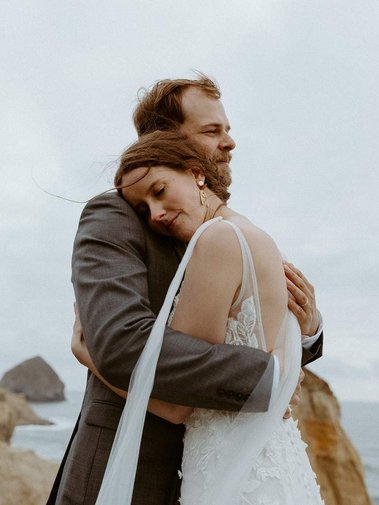 Bride and groom taking their elopement picture by canon beach. very clean makeup and soft hair updo
