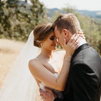Bride with classic wedding bridal updo holding groom's face.
