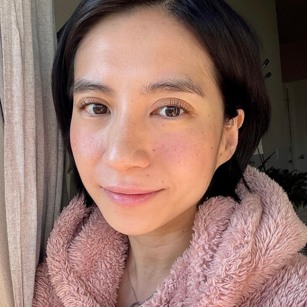 Asian girl with minimal makeup and glowing skin. Middle-parted, short hair. 