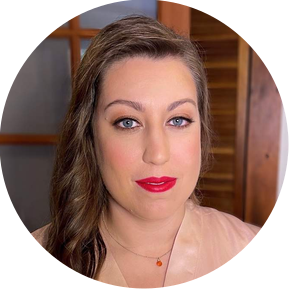 Bride with bronze-colored smokey eyes and red lips. She has wavy hair on her side. 