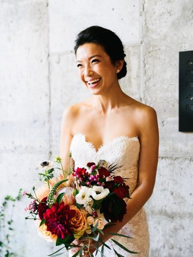 sophisticate Asian bride with very natural makeup and classy updo holding a flower bouquet. 