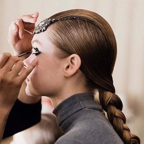 Model is spot at NYC Fashion week, hair is in a sleek braid with delicate accessary. 