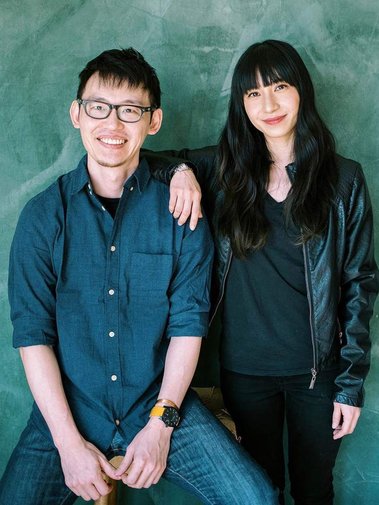 Asian couple posing in front of green backdrop. They are the best wedding makeup and hair team in Vancouver WA, Portland OR