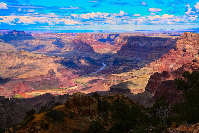 The immense magnitude of the Grand Canyon is absolutely amazing. 
Approximately 1.6 km deep and nearly 30 kms at its greatest width. 
The Colorado River flows in it for nearly 445 kms.