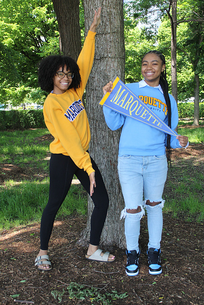 Natalie beams with pride on Decision Day, holding her college pennant high as she celebrates her next big step toward a bright future.