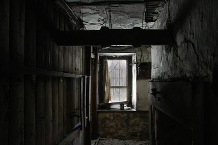 The view from inside an abandoned house during a strong snowstorm