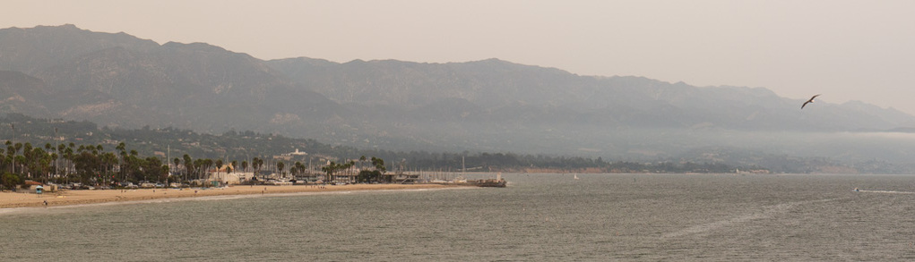 photo of a santa barbara, california beach during the day with the mountains in the background