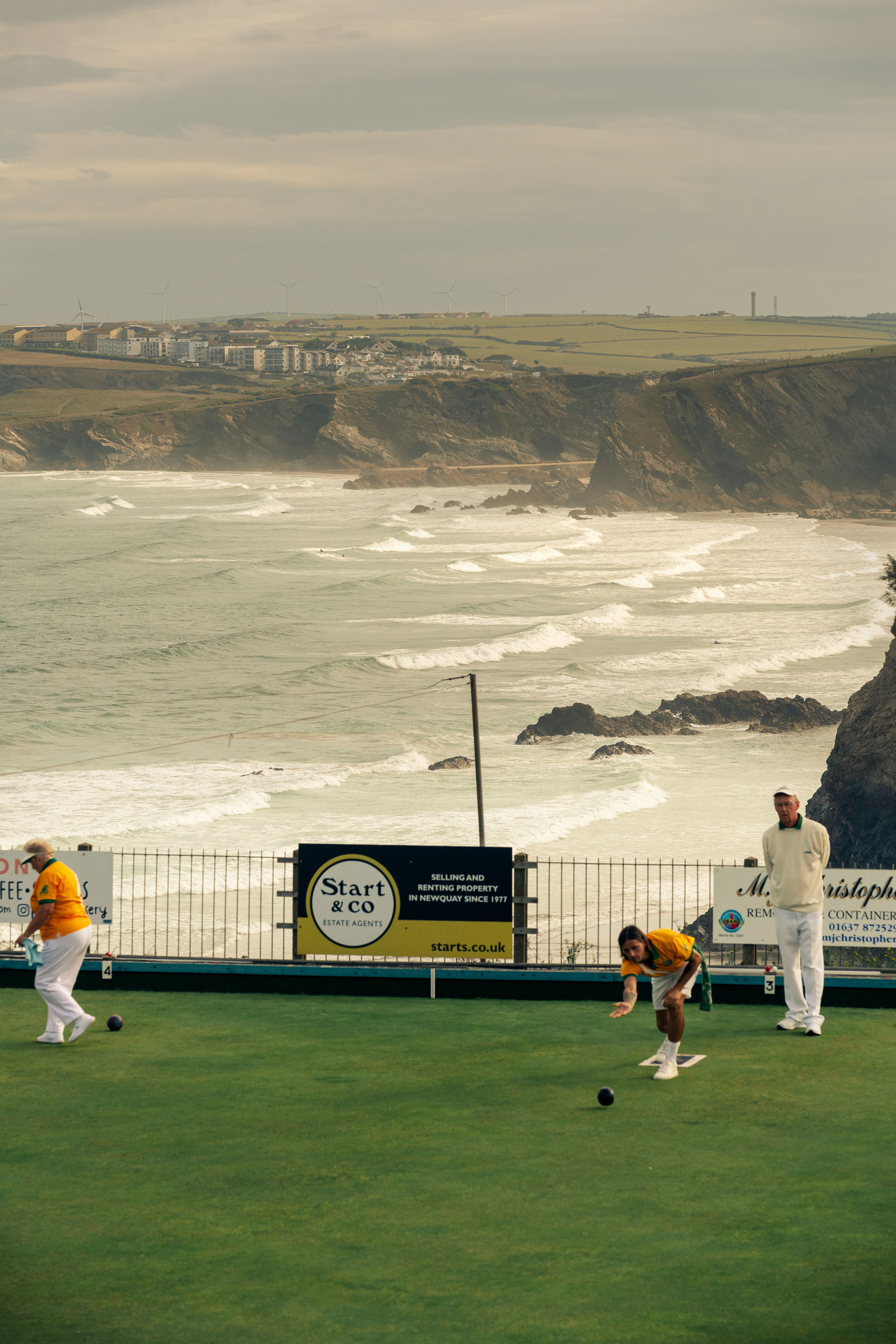 Newquay West End Bowls Club playing at their location above the Newquay harbour, in Cornwall, Western England. Proceedings sponsored by a local funeral director.