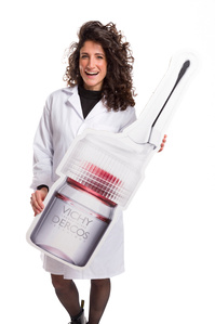 Ritratto con cartellone prodotto vichy formato gigante, evento effettuato a milano per il concorso farmaciste Vichy foto di Riccardo Alessio STOOD studio fotografico