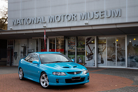 National Motor Museum with a holden Monaro parked at the front of the museum.