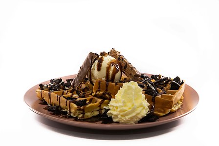 Waffles with ice cream and cream with chocolate sauce.