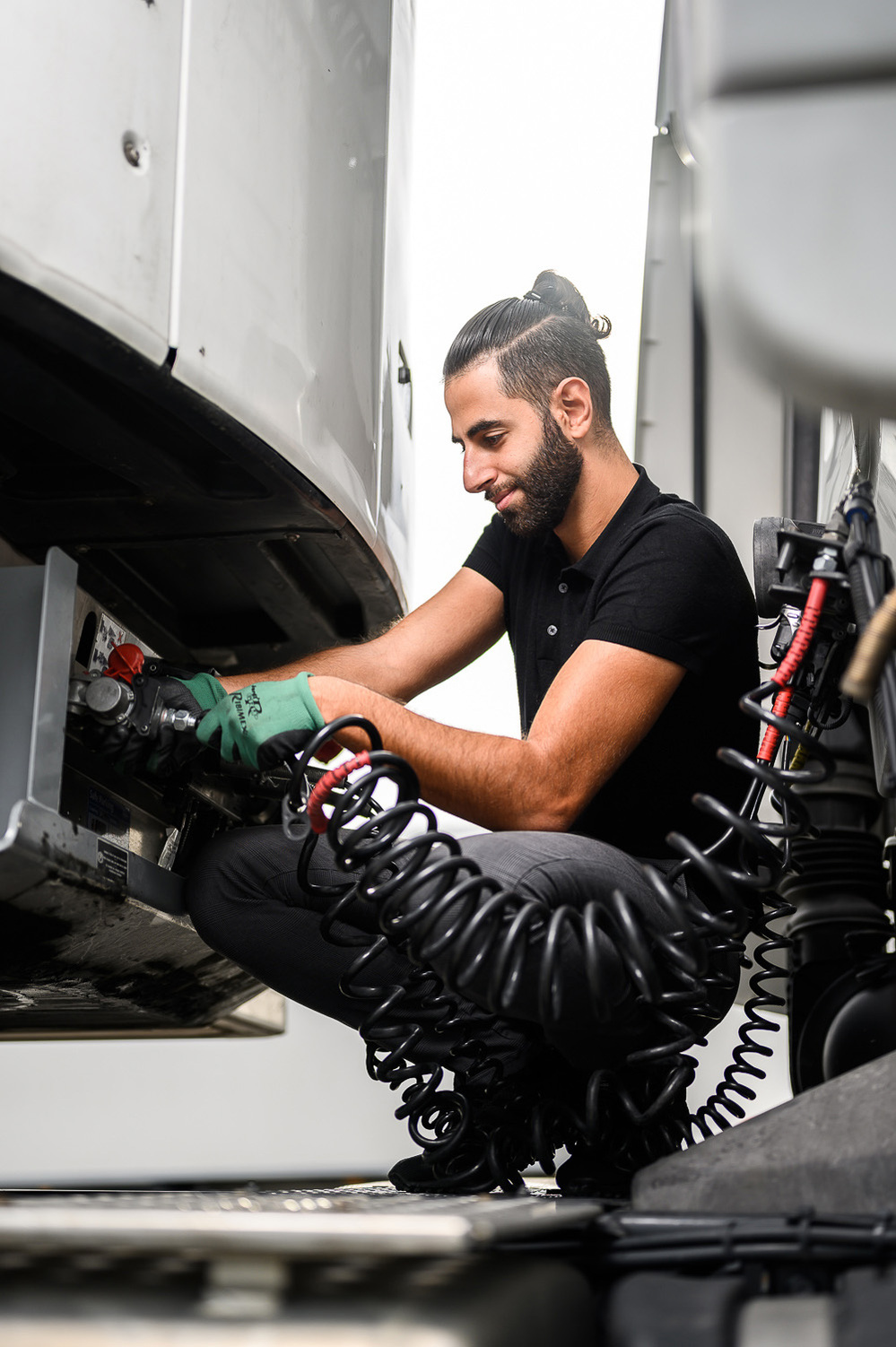 Photographie de portrait entreprise d'un homme jeune chauffeur routier en train d'effectuer une opération sur sa remorque
Lotfi Dakhli Photographe Lyon