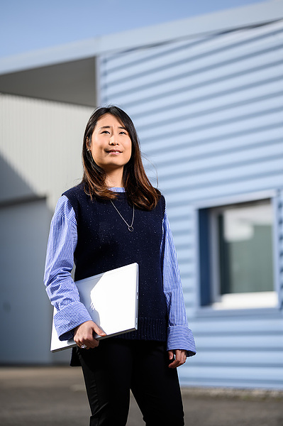 Photographie de portrait entreprise femme asiatique tenant un ordinateur portable 
Lotfi Dakhli Photographe Lyon