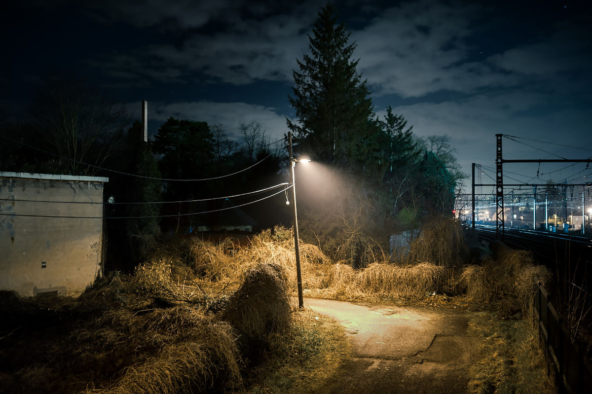 photographie urbaine de nuit rue isolée sous un éclairage publique créant un ambiance cinématographique