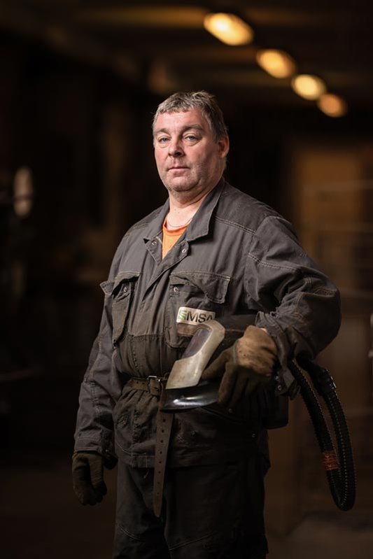 portrait industriel homme dans un atelier portant un casque de soudeur