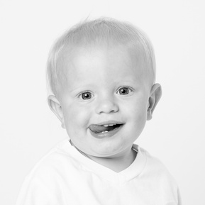 adorable baby boy smiling with tongue out in black and white