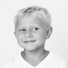 blonde hair boy with a silly grin in black and white