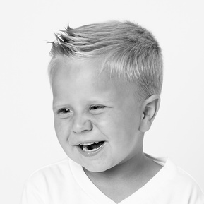 toddler boy laughing in a black and white portrait