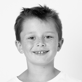 dark haired boy smiling in black and white