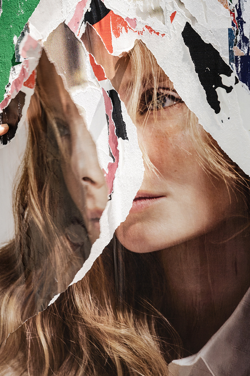 A shredded double portrait of a young white woman with long blond hair looking sad. Her duplicate image is hanging losing over the same image providing a "split personality" or schizophrenic meaning to this photo. Woeful. Forlorn. Sad. Shattered