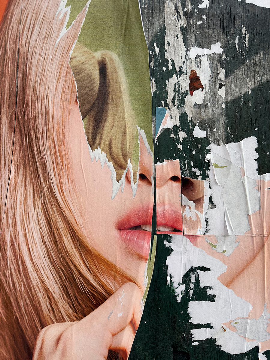 This surrealistic image of a white woman with pink lipstick on a torn advertising poster is torn down the middle, leaving her without eyes and showing a green background with the back of a head in a ponytail. The image reflects anonymity.