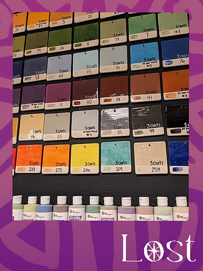 Gallery Image: Text reads: LOST. On a purple border around an image of a paint-chip grid. Row 1- shades of green,  2 - shades of blue, 3 - shades of brown, 4- shades of grey, and 5 - bright colours. Along bottom are a row of paint bottles.