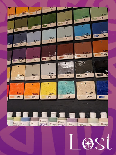 Gallery Image: Text reads: LOST. On a purple border around an image of a paint-chip grid. Row 1- shades of green,  2 - shades of blue, 3 - shades of brown, 4- shades of grey, and 5 - bright colours. Along bottom are a row of paint bottles.