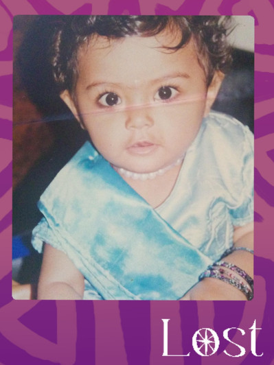 Gallery Image: Text reads: LOST. On a purple border around an image of a young toddler aged child wearing a blue satin sash and looking at the camera. The baby has two bracelets on and a tiny pearl necklace on.