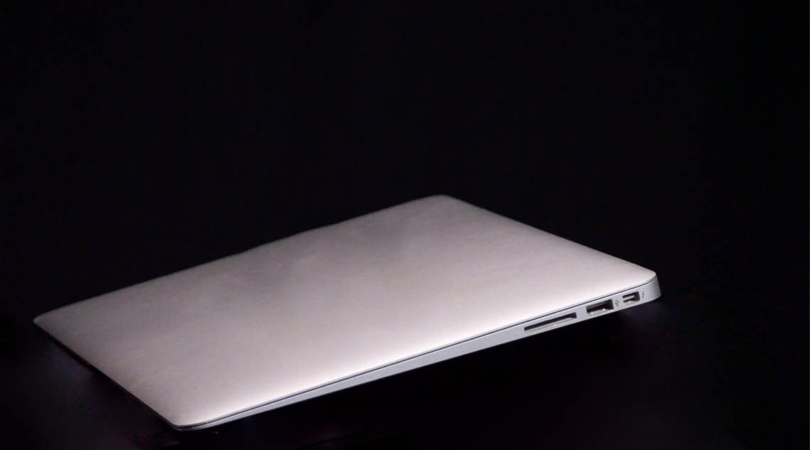 Image of a silver apple computer on a black background. The computer slopes from the upper right of the image down to the lower left corner.