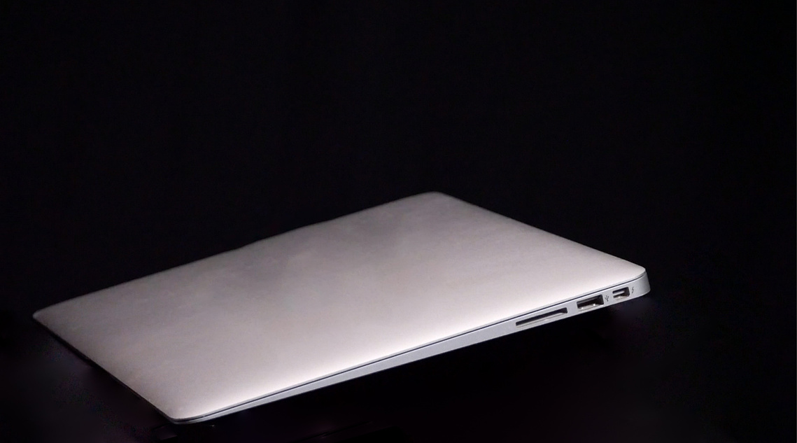 Image of a silver apple computer on a black background. The computer slopes from the upper right of the image down to the lower left corner.