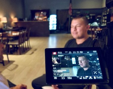 man on chair being filmed