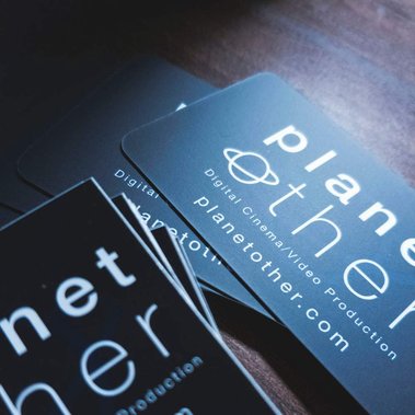 stack of PlanetOther business cards and promotional stickers