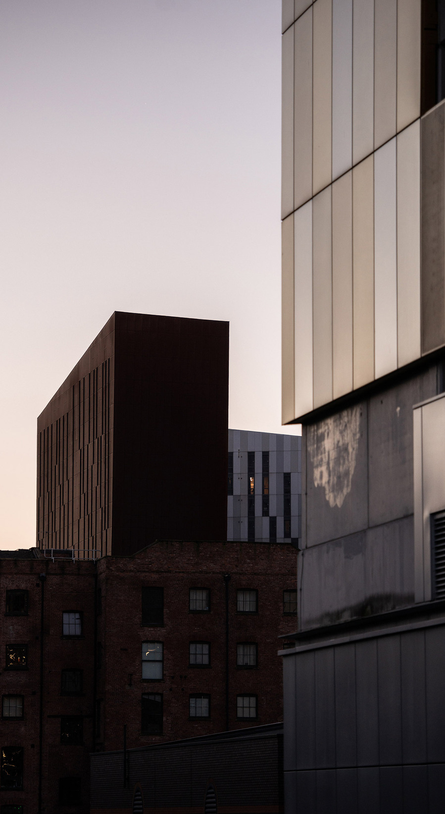 cropped image of modern city buildings against pink sky