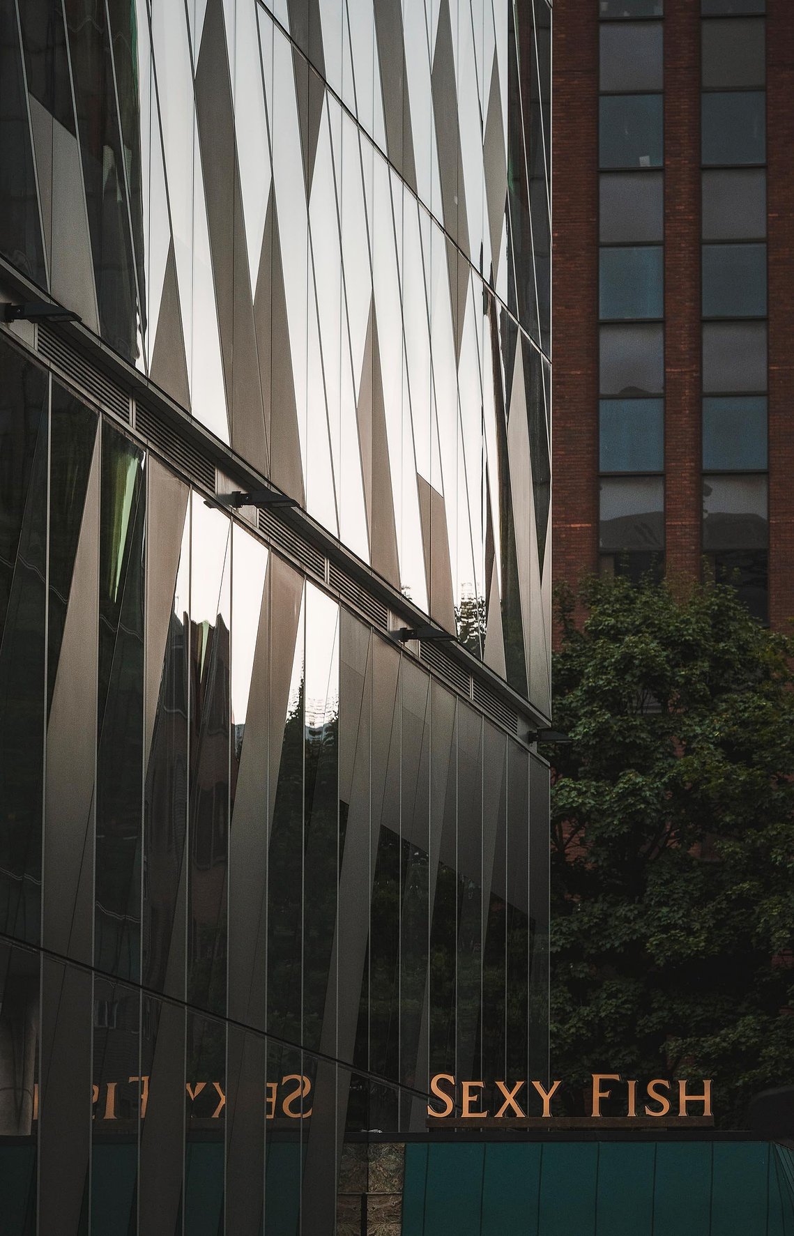 URBAN LIFESTYLE AND LOCAL AREA PHOTOGRAPHY OF SPINNINGFIELDS, MANCHESTER, shot of glass building in evening light and signage for restaurant 