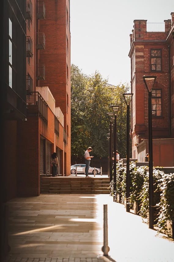 URBAN LIFESTYLE AND LOCAL AREA PHOTOGRAPHY OF SPINNINGFIELDS, MANCHESTER, lifestyle photography showing person on phone with tall buildings and steps
