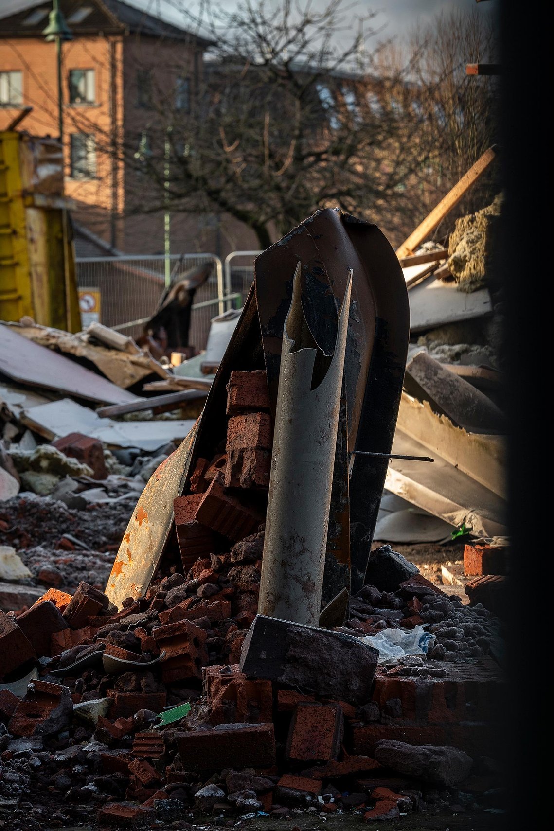 demolition works on site of shopping centre, twisted metal on ground
