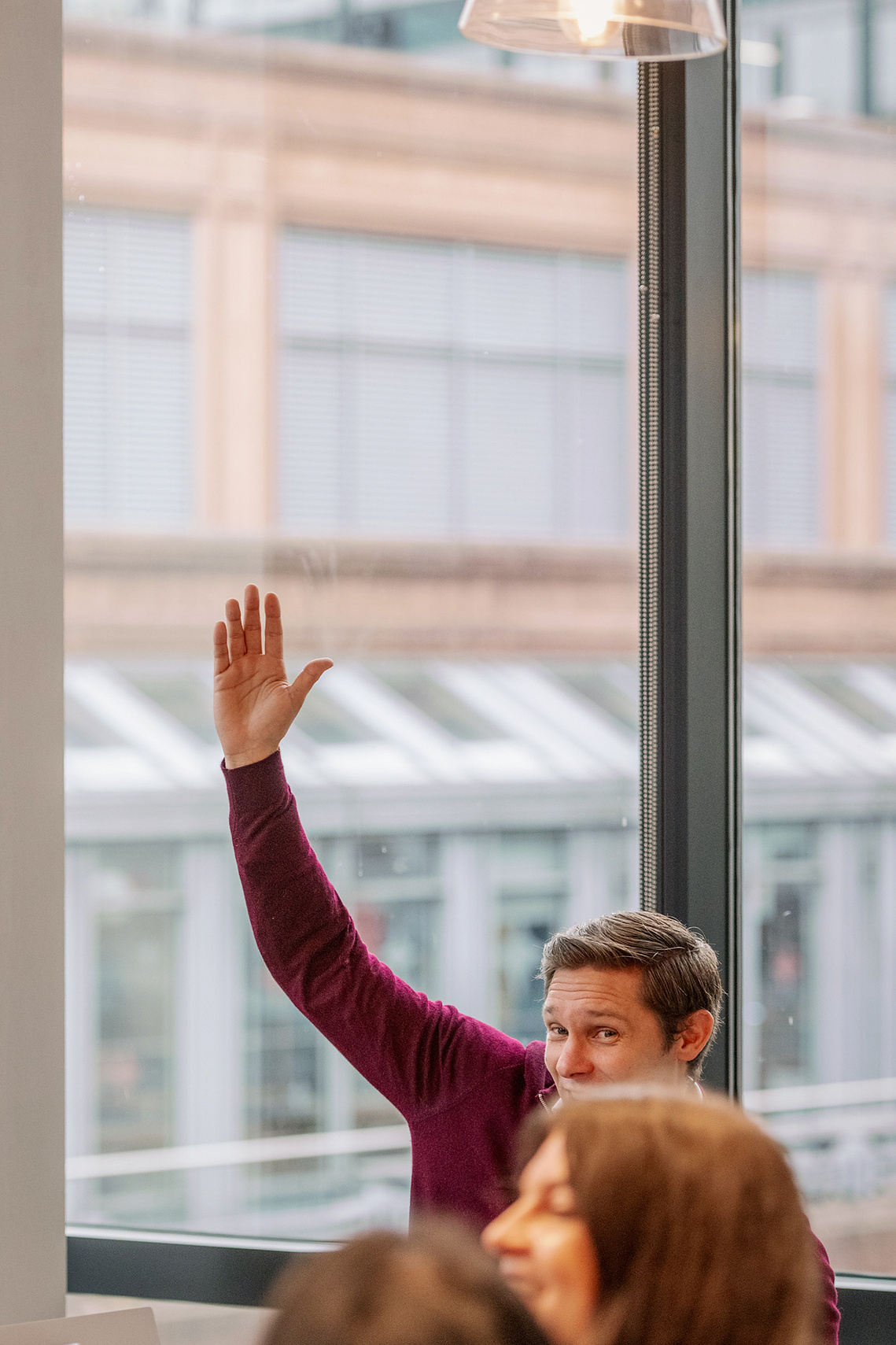Commercial lifestyle photography worker with hand up in collaboration London office