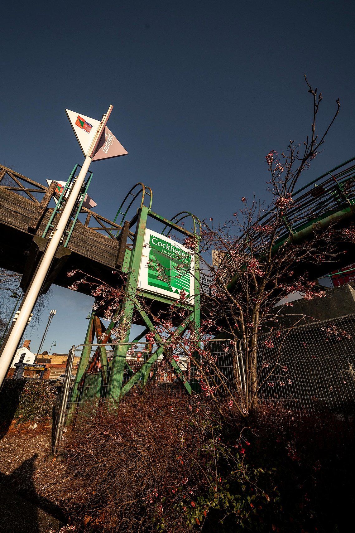 Photo looking up at old shopping centre signage against a blue sky
