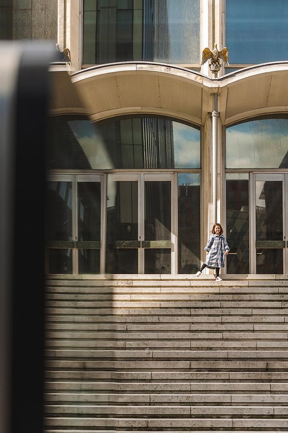 URBAN LIFESTYLE AND LOCAL AREA PHOTOGRAPHY OF SPINNINGFIELDS, MANCHESTER, lifestyle photography showing a small child playing on the steps in front of a building sunshine 