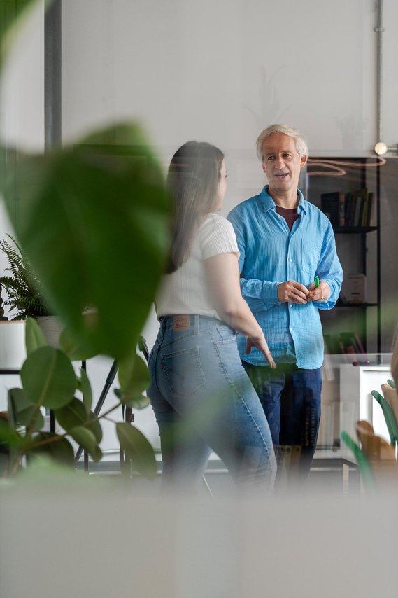 commercial lifestyle photography showing staff in a workplace, team members stood discussing work in meeting room