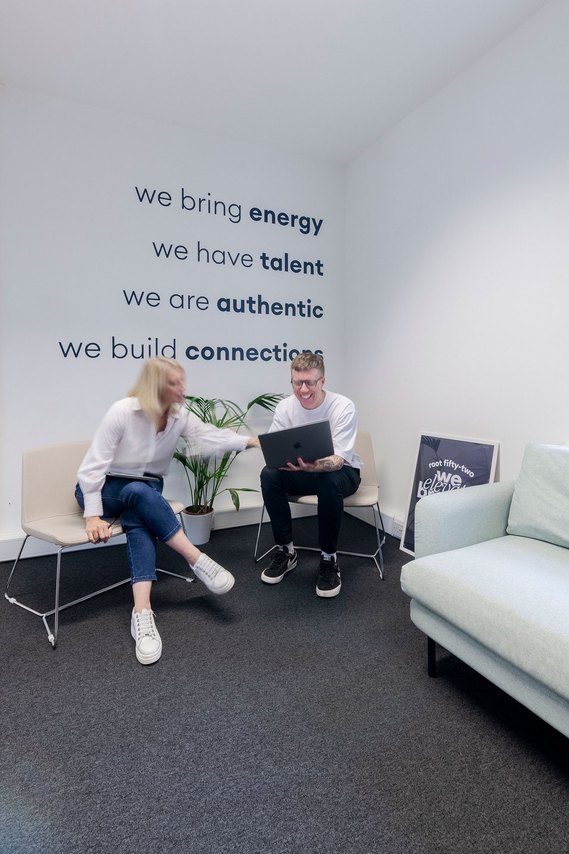 commercial lifestyle and office lifestyle, workplace, team members sit in armchairs and discuss work on a laptop