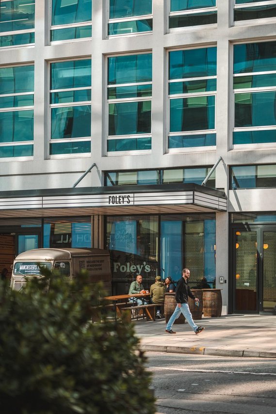 URBAN LIFESTYLE AND LOCAL AREA PHOTOGRAPHY OF SPINNINGFIELDS, MANCHESTER, lifestyle photography shows customers sitting outside coffee shop with person walking past