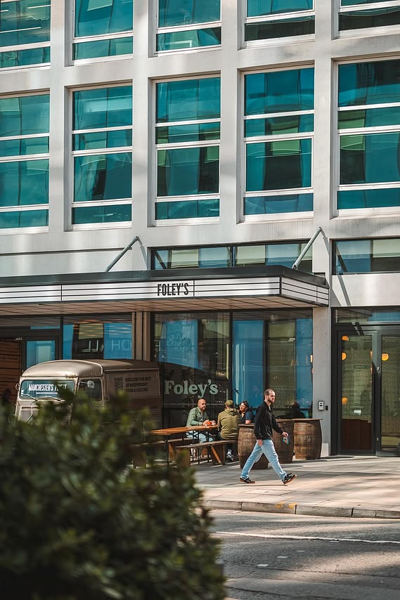 URBAN LIFESTYLE AND LOCAL AREA PHOTOGRAPHY OF SPINNINGFIELDS, MANCHESTER, lifestyle photography shows customers sitting outside coffee shop with person walking past